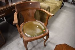 An early 20th Century oak office armchair having shaped legs and double stretcher