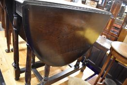 A Priory or Dark Ercol style drop leaf dining table