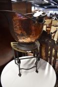An antique brass and cast footman and a copper coal helmet
