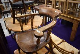 A late Victorian smoker bow arm chair having elm seat and turned supports