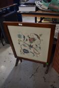 An early mahogany folding firescreen/tea trolley, having embroidered panel