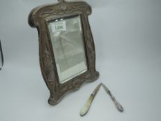 An Edwardian silver table mirror of shaped rectangular form having moulded water lily and bird
