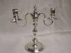 A silver candelabra having central shaped column to three candle holders, two having wax saucers,