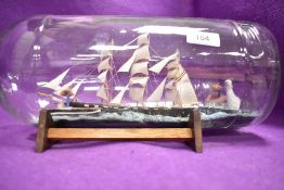 An early 20th century model of a ship in a bottle 50cm long