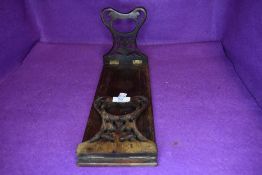 A mahogany book self having carved folding ends