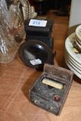 A lucas bike lamp and vintage light meter.