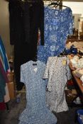 Four ladies retro dresses with tags still attached.