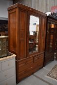 A Victorian mahogany mirror door wardrobe having drawer base