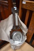 An early 20th Century oak cased barometer of typical design having thermometer dial