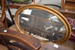A gilt frame oval wall mirror