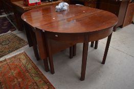 A Georgian mahogany dining table having drop leaf centre and two D ends, line inlay decoration to