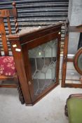 An Edwardian corner cupboard having leaded light glazed door