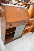 A mid 20th Century oak bureau with bookcase below