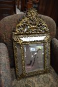 A 19th Century gilt and brass cushioned wall mirror