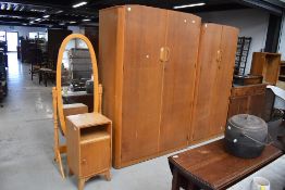 A vintage Austinsuite bedroom suite comprising two graduated wardrobes and a bedside cabinet , in