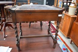 An early 20th Century oak piano stool having twist legs