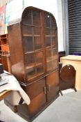 A 1930s oak display cabinet having arch top display section over double cupboard