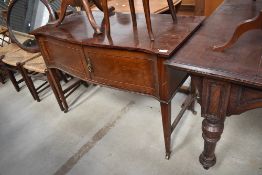 A Victorian side board in a regency style having serpentine front on tapered legs