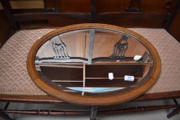 An early 20th Century oak oval wall mirror