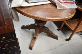 A modern oak circular dining table having bulbous column and chunky legs