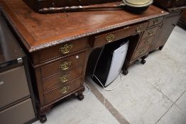 An early 20th Century Period style pedestal desk having leather inset top, brass Georgian style