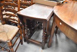 A traditional oak gate leg kitchen table having twist legs
