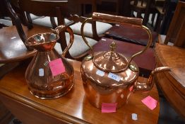 A traditional copper and brass kettle and similar squat jug