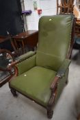 A 19th Century leather library style armchair having scroll arms