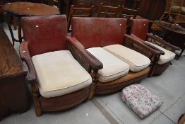 An early Ercol Arts and Crafts three piece suite having embossed leather back, bergere cane sides,
