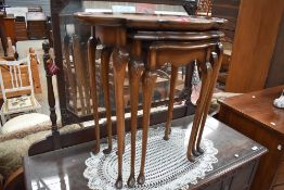 A vintage stained frame nest of tables having shaped top and cabriole legs