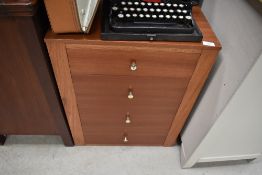 A vintage laminate teak effect bedside or office chest of four drawers
