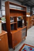 A vintage teak shelf unit having open shelves over sliding glass/solid doors, width approx. 106cm