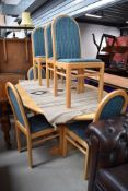 A modern Ash oval dining table and 6 chairs having upholstered seats and backs