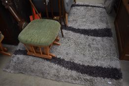 A modern shag pile rug, grey wave pattern