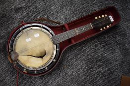 A late 19th or early 20th Century mandolin banjo (af with damage to skin and half case)