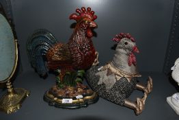 Two door stops in the form of chickens or hens one being cast metal and the other fabric