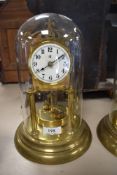 A vintage brass anniversary clock having glass dome and enamel face,marked for Badische.