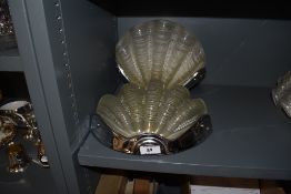 A pair of wall mounted light fixtures or fittings having sea shell style pressed glass