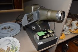 A vintage Aldis projector and metal case containing slides.