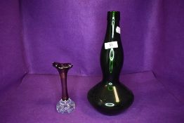 A bell bottom green glass wine bottle and a similar art glass posy vase