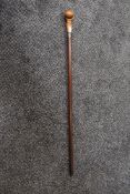 A 1920s cane or swagger stick having hallmark for Chester to cuff, with carved hand holding ball