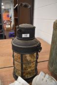 A vintage lantern having glass faces to sides and pivoting handle.