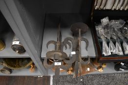 A pair of wrought iron wall mounted candle sticks