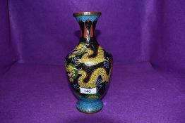 A vintage cloisonne vase being decorated with mythical Japanese dragon