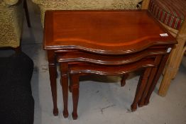 A modern nest of three mahogany effect tables