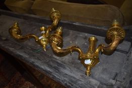 A pair of brass cast wall mounted light brackets