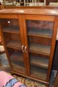 An Edwardian mahogany framed display case or book shelf having rolled glass frontage