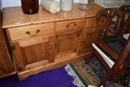 A modern yellow pine side board or dresser base having three drawer and under cupboards
