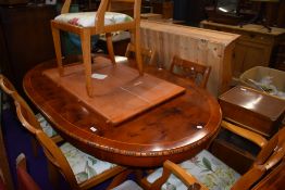 A modern extendable dining table and set of six chairs in yew and beech woods