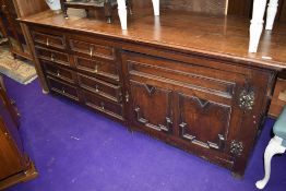 A mid Victorian long dresser base or side board having gothic style oak frontage